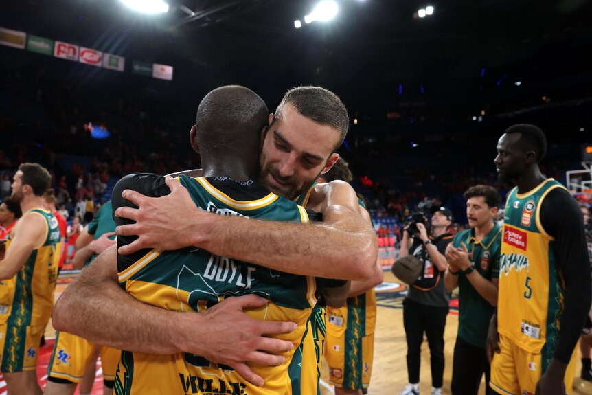 Two Tasmania JackJumpers players embrace after defeating Perth Wildcats.