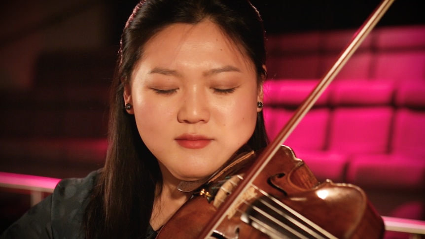A close up of Emily Sun playing the violin.