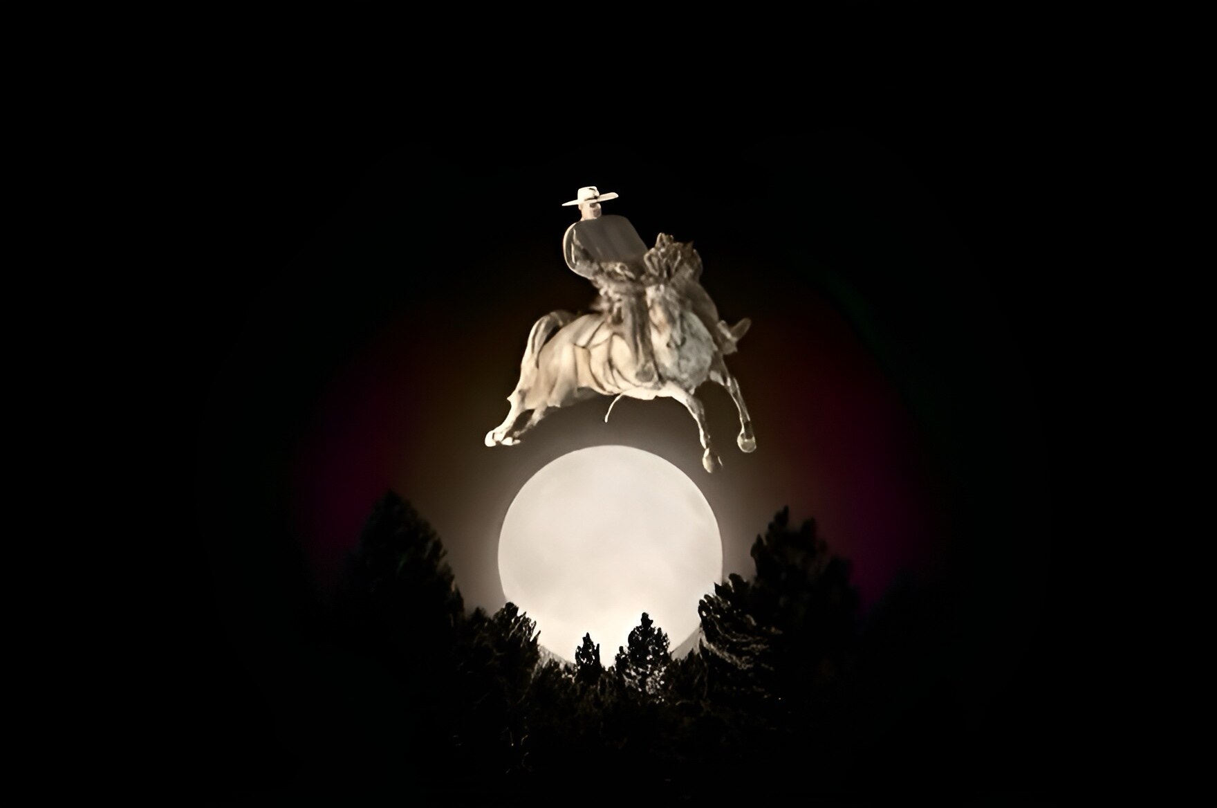 The moon over sillhouttes of tall trees with a cowboy riding a horse over the moon