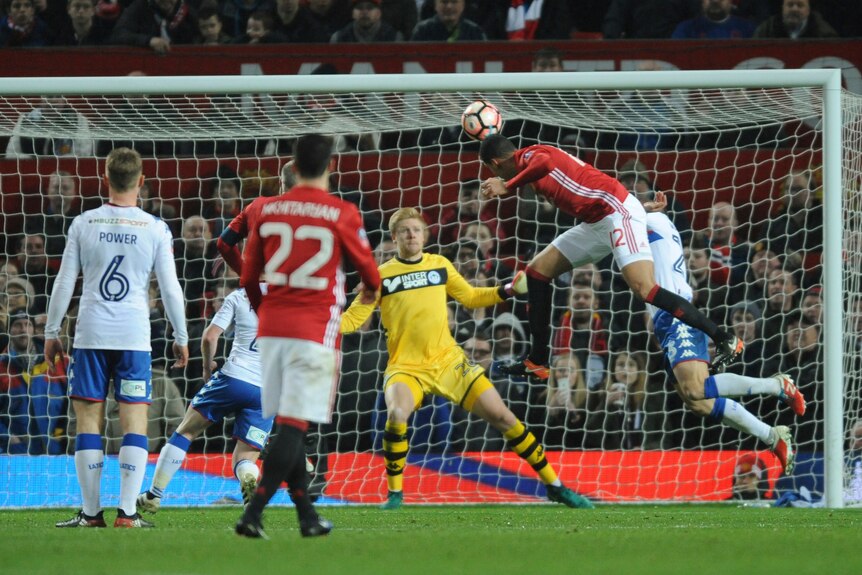 Manchester United's Chris Smalling (R), scores against Wigan Athletic in the FA Cup.