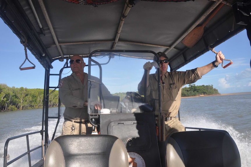 Two rangers riding on a boat.