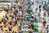 A packed supermarket with jammed checkouts, seen from above.