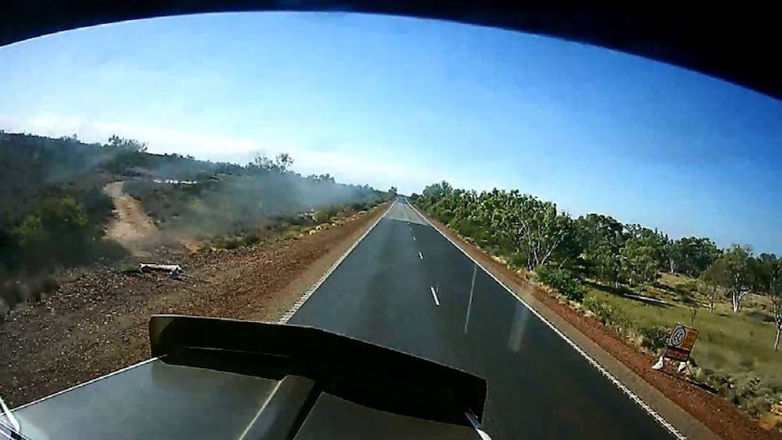 A still taken from dash cam footage showing a road sign was laying flat beside the road.
