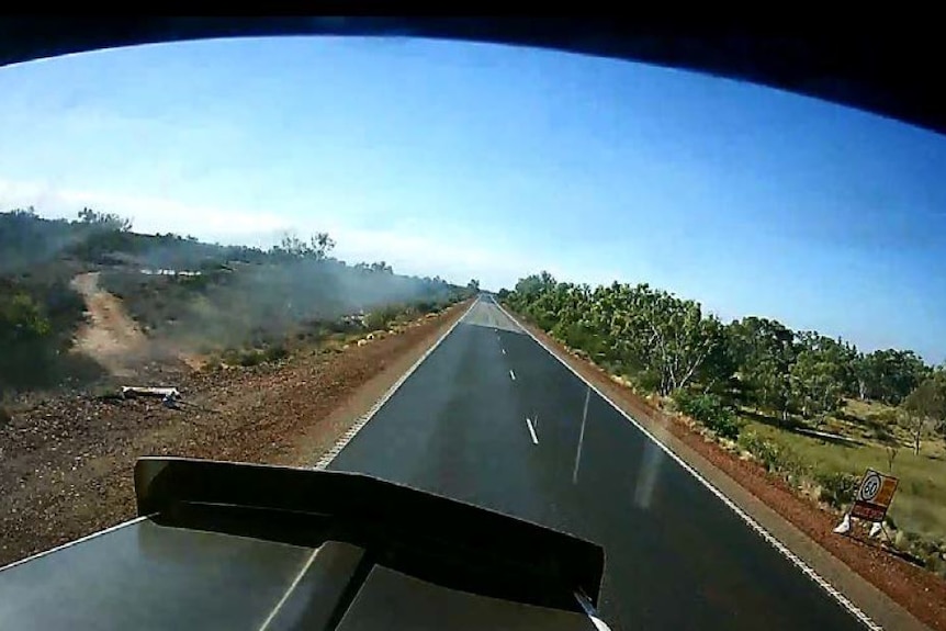 A still taken from dash cam footage showing a road sign was laying flat beside the road.