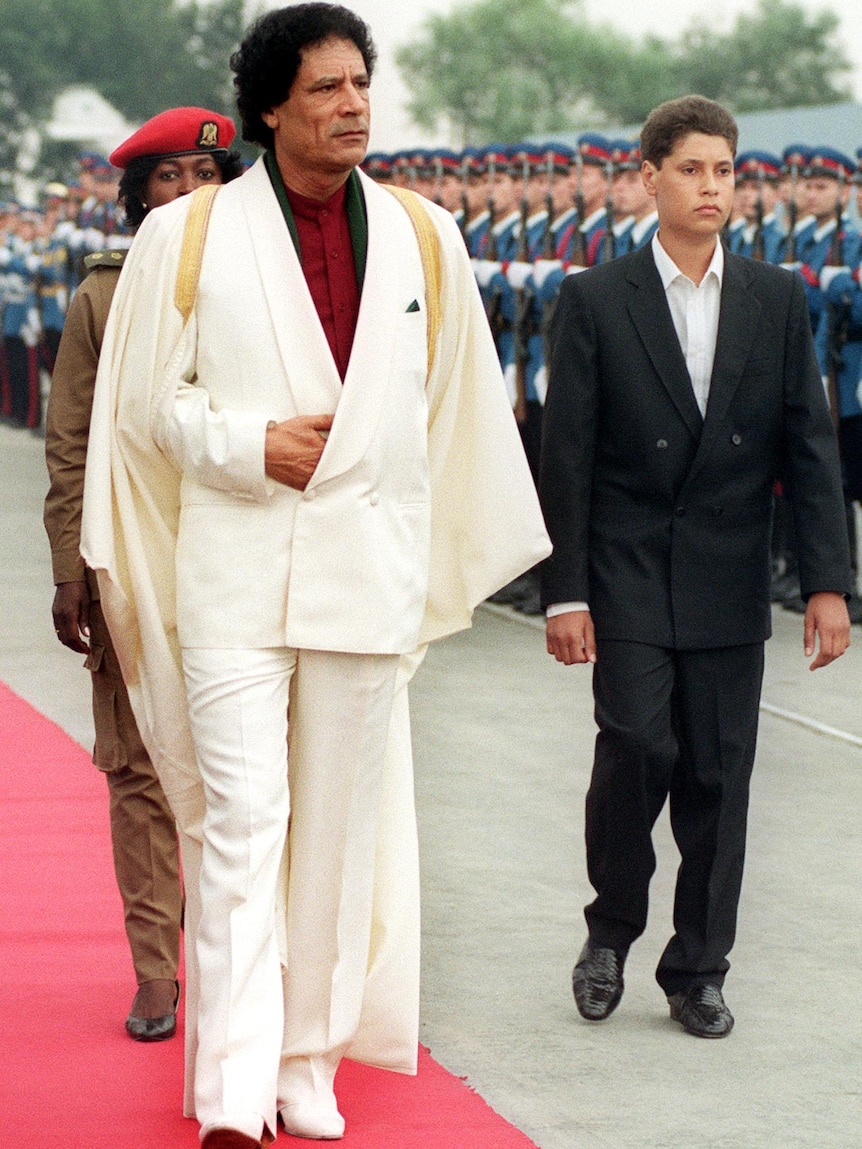 Moamar Gaddafi and his son Saif Ul-Islam inspect troops in 1989.