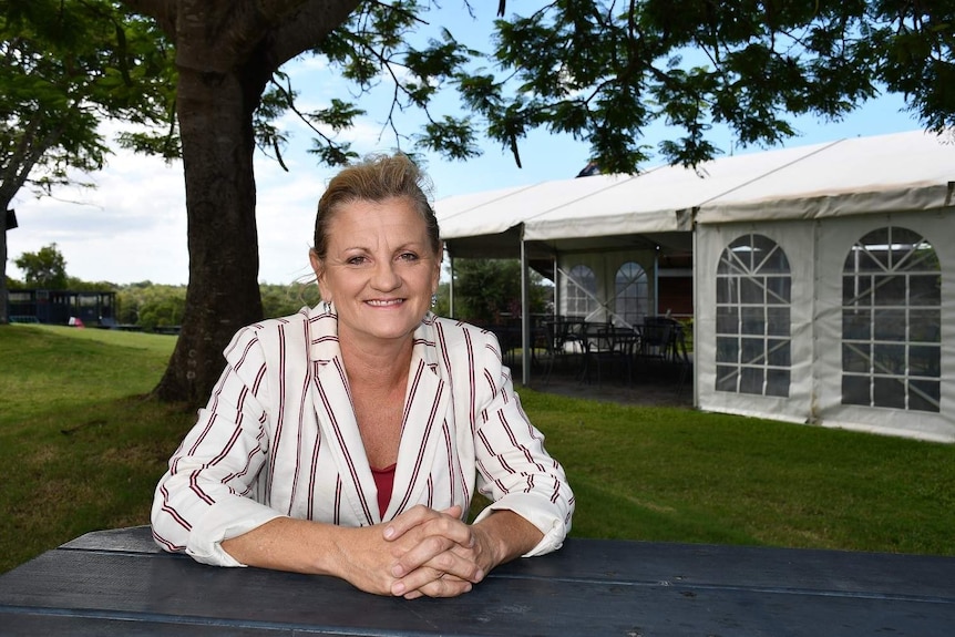 Former Redland Mayor Karen Williams sit at a table at a park.