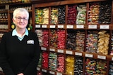 Sally McGregor stands to the left hand side of a shelves of confectionary inside the shop