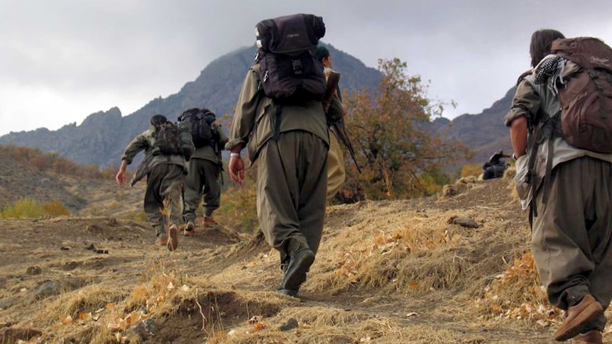 PKK fighters walk in unknown mountains.