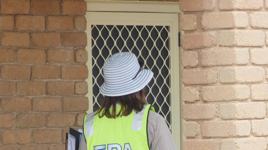 An EPA worker knocks on a door