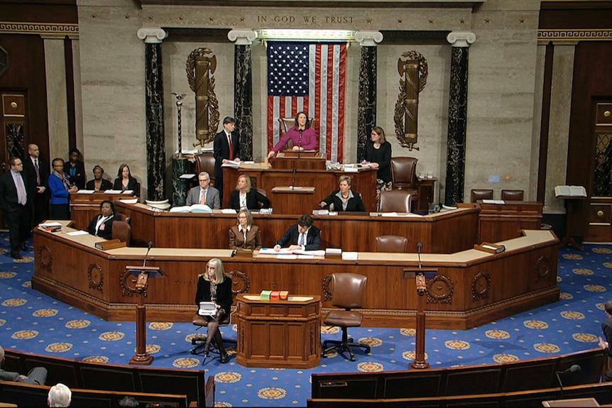 Members of the House of Representative walk on the floor as voting begins.
