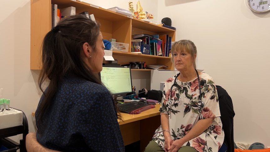 Two women sit in medical consulting room