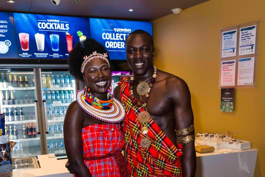 A young couple, both African descent, pose in amazing outfits.