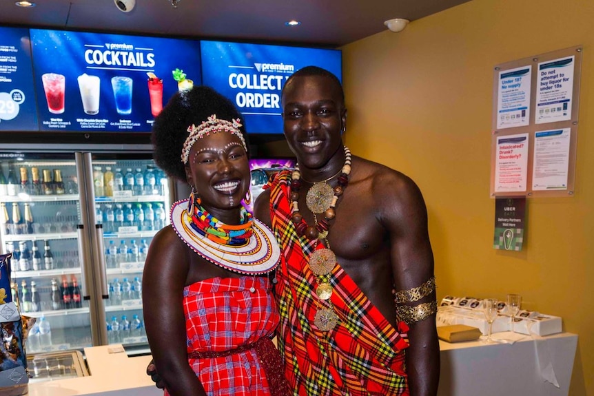 A young couple, both African descent, pose in amazing outfits.