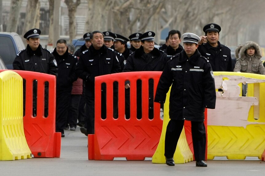 Police gather near road blocks around Shijiazhuang Intermediate People's Court in Shijiazhuang.