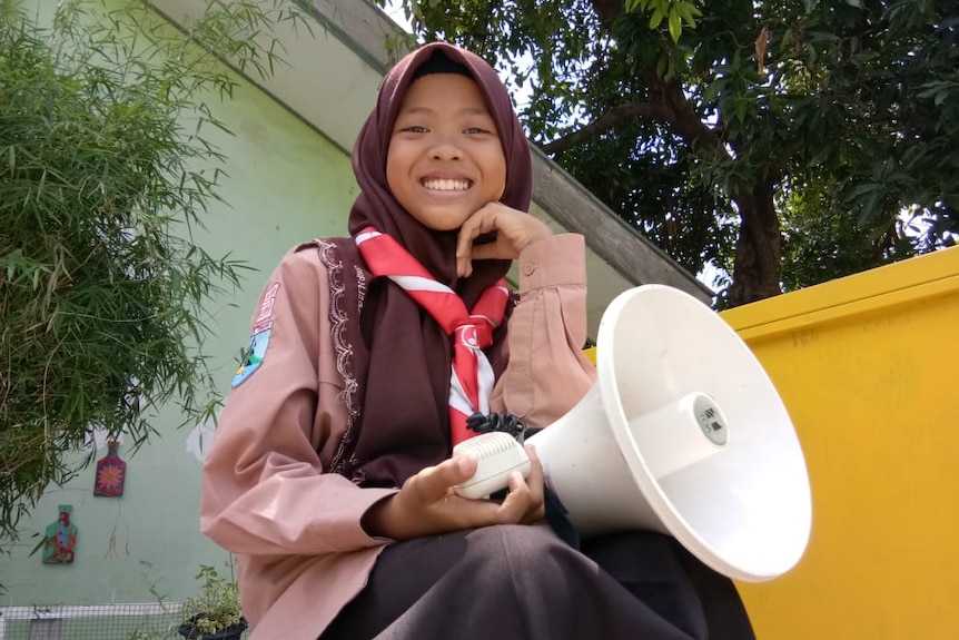 Aeshninna Azzahra holds a megaphone.