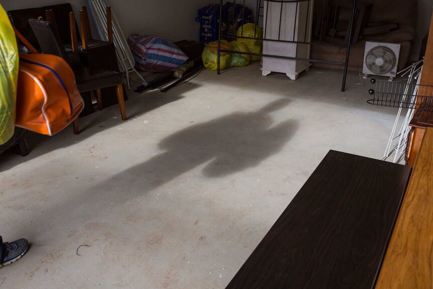 Matt's shadow falls on the floor of the garage.