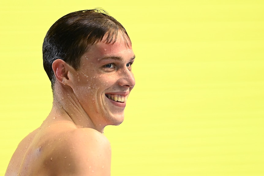 Zac Stubblety-Cook smiles in front of a yellow background