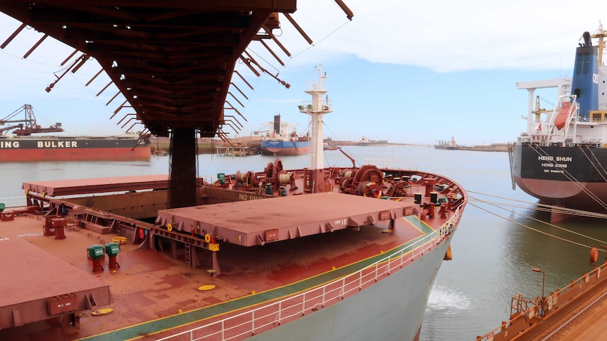 Iron ore drops from a conveyor belt into the hatch of a ship at the FMG port at Port Hedland.