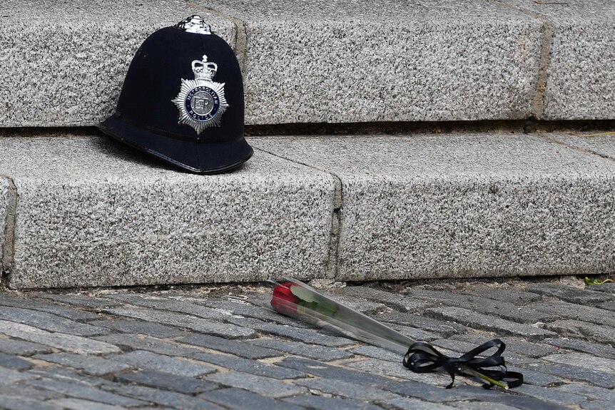 A single rose lies on the ground in front of PC Palmer's helmet.