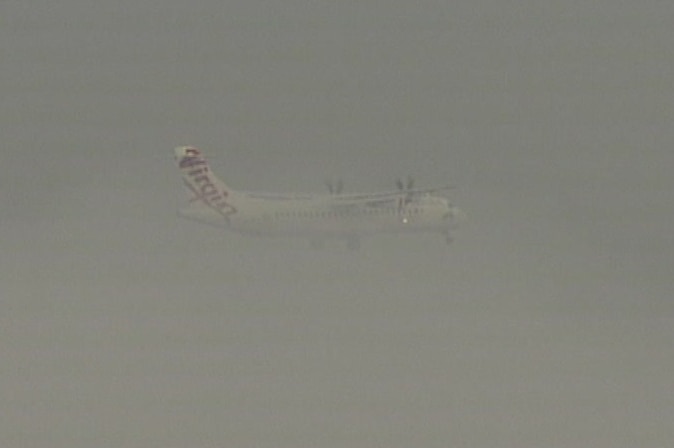 A Virgin plane navigating the fog over Sydney this morning