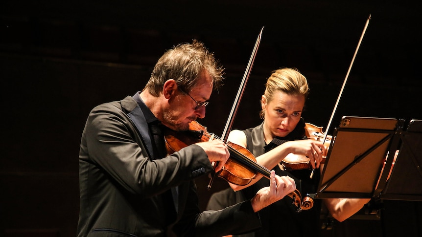 Richard Tognetti and Satu Vanska playing violin on stage