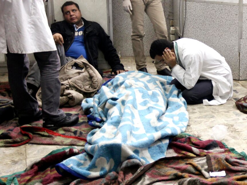 Men mourn next to the body of a protester at a field hospital near Tahrir Square, Cairo.