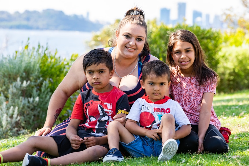 A woman sitting with three children.