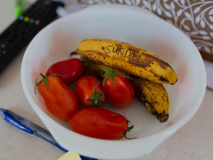 Banana and tomatoes in a bowl, with Sunday drawn on the outside of a banana in black pen
