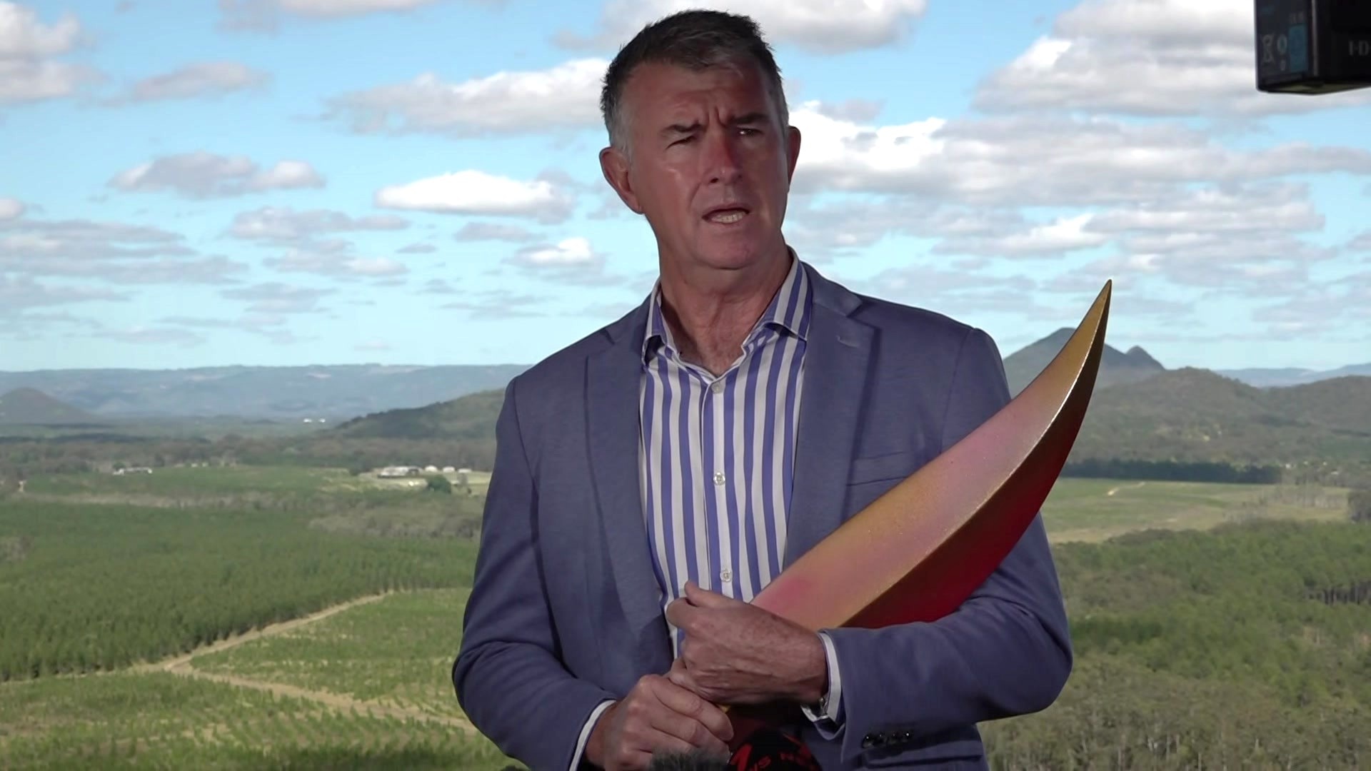 Olympics Minister Tim Mander holding a piece of the Brisbane 2032 emblem.