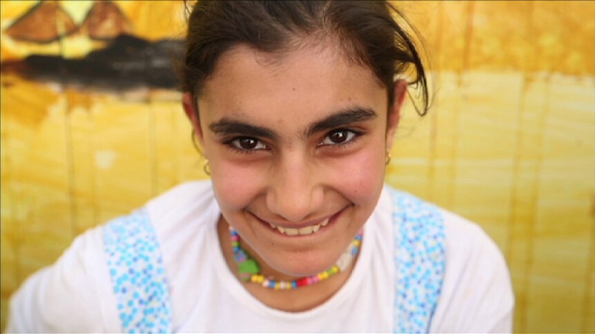 12-year-old Dina Hariri smiles at the Zaatari refugee camp in Jordan.