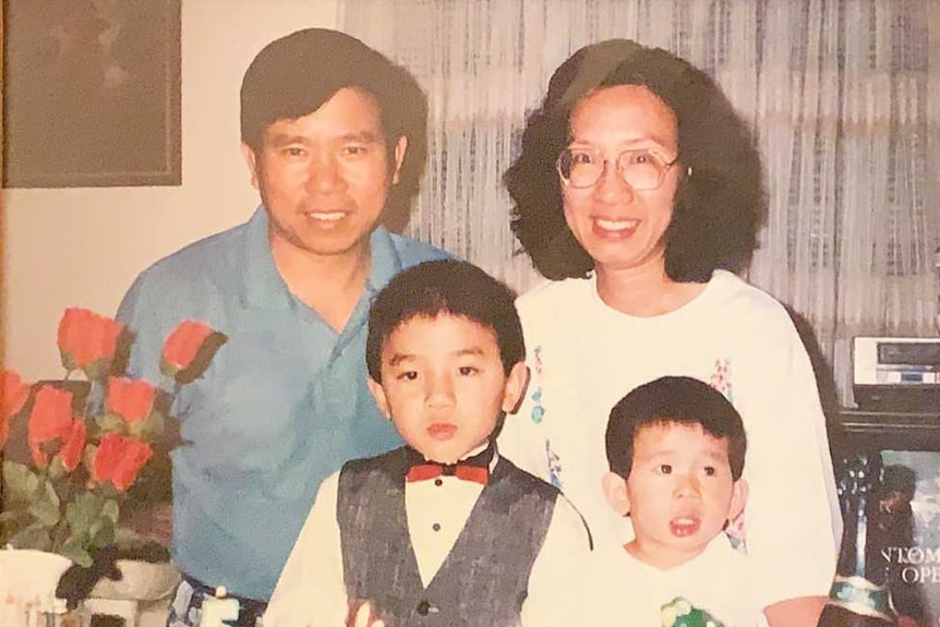 A picture of a husband, wife, and two young sons in an old framed photo. 