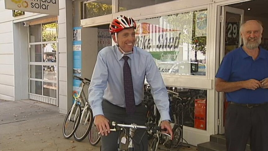 Environment Minister Simon Corbell riding an electric bicycle in Canberra.