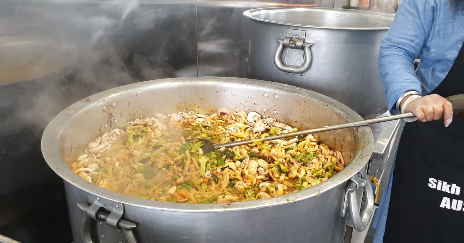 Food is being cooked in a large pot in a kitchen.