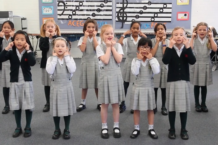 A group of primary school students singing together.