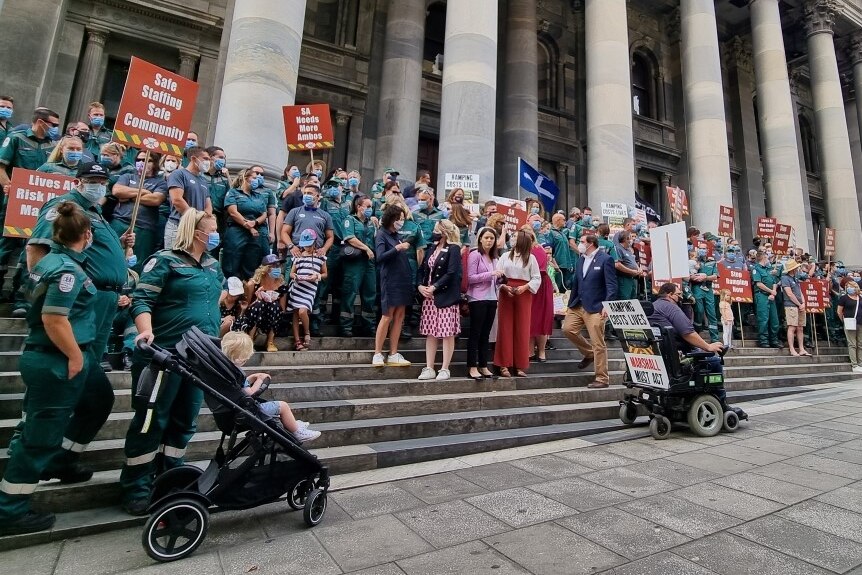 Paramedics and other people protest in front of Parliament House