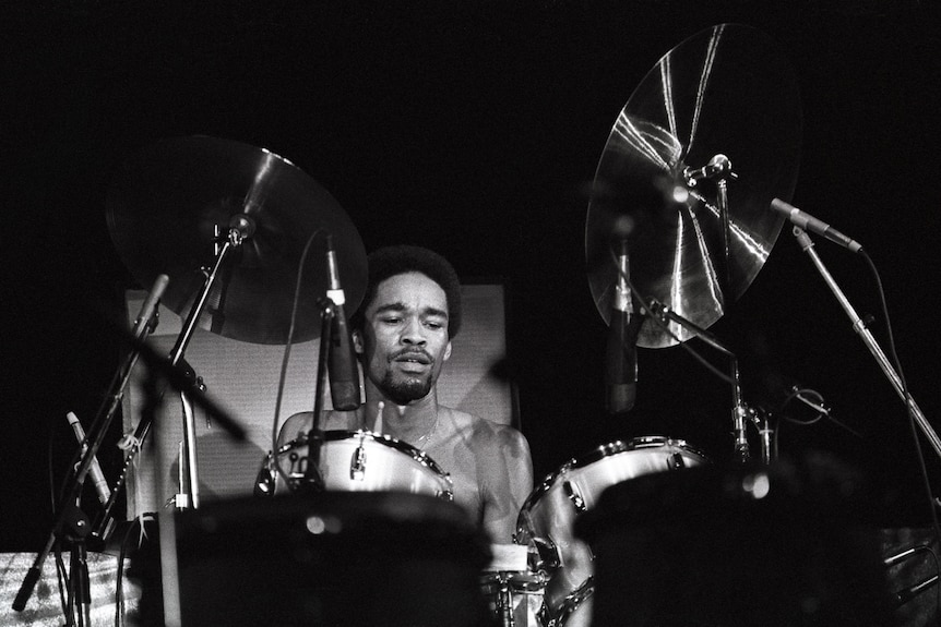 Fred White sits behind a drum kit while playing for Earth, Wind and Fire.