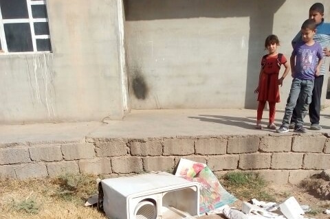 Children in the Ibrahim family look at a washing machine IS militants threw into in the courtyard of their home.