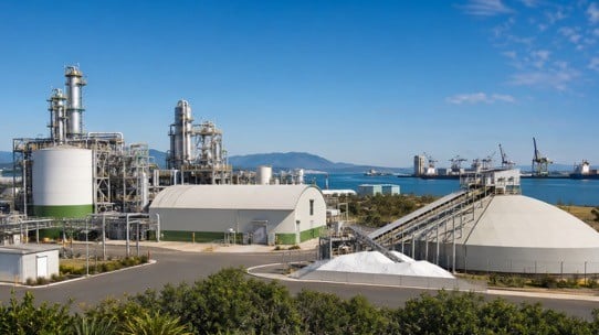 A wide shot of an industrial plant with urea in the foreground and water in the background