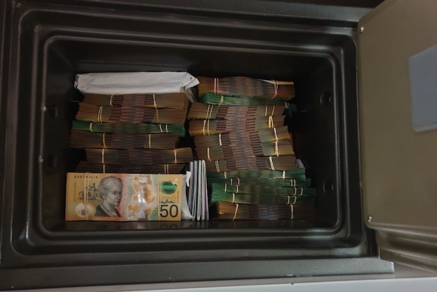 Bundles of $50 and $100 notes are stacked high in a safe.