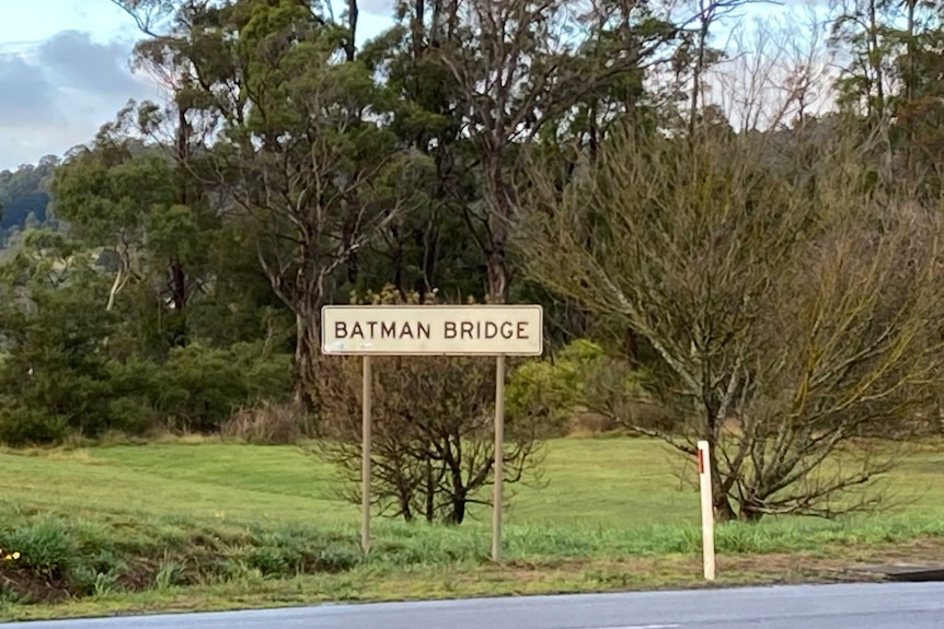 A sign saying Batman Bridge with bushland in the background in northern Tasmania