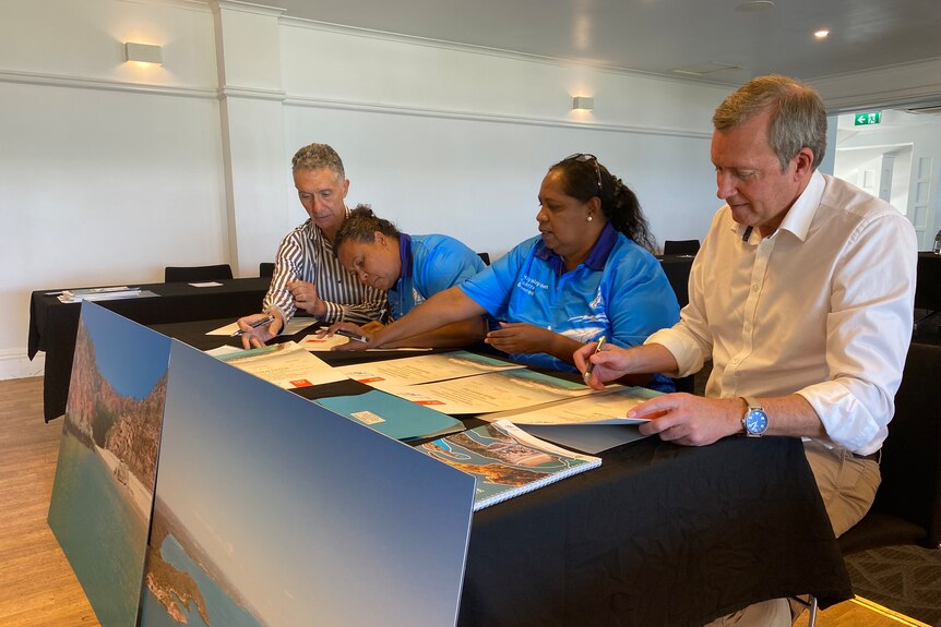 Minister Tony Buti and Reece Whitby watch on as two Mayala representatives sign papers
