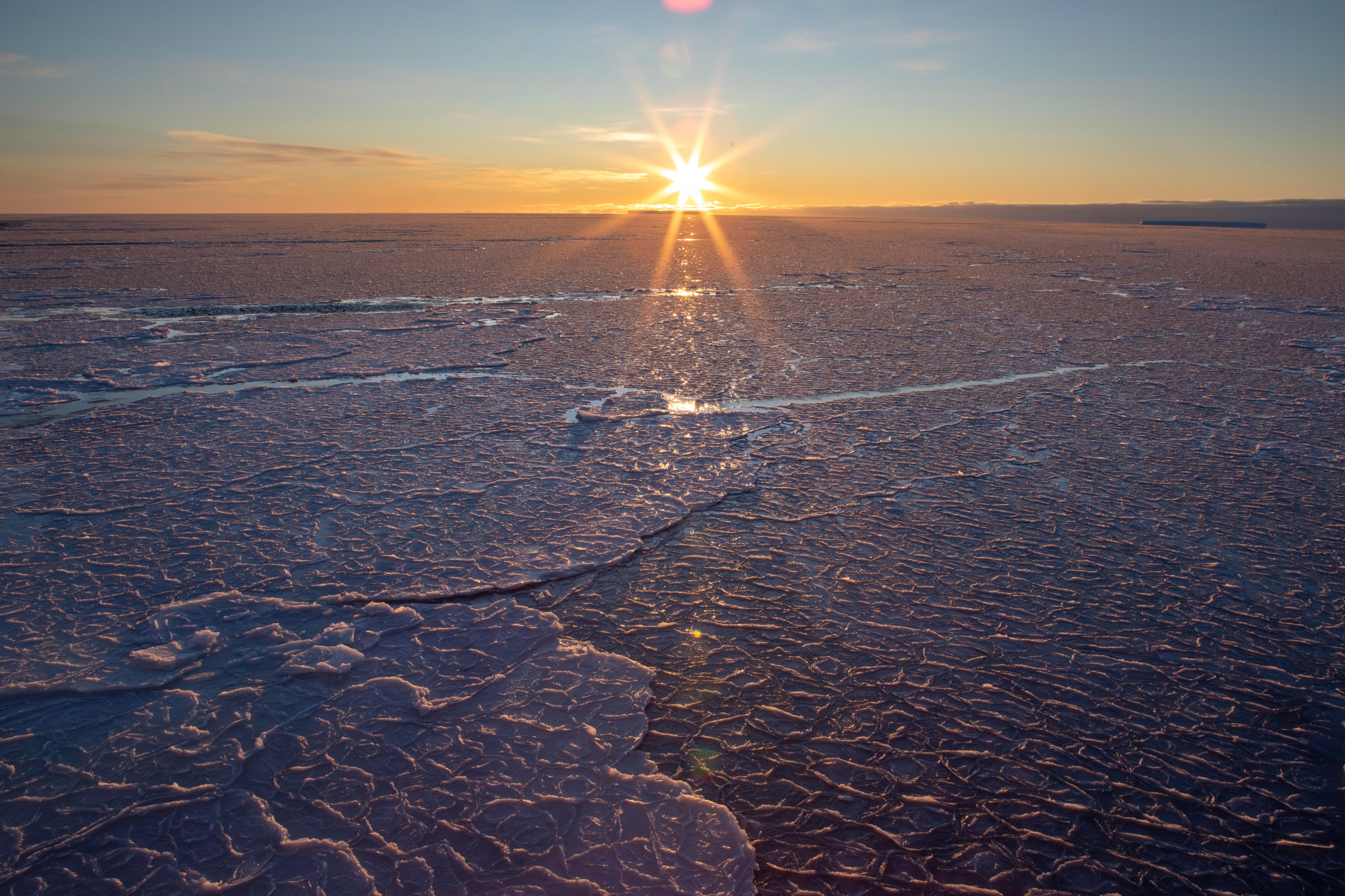 The sun sets over ice.