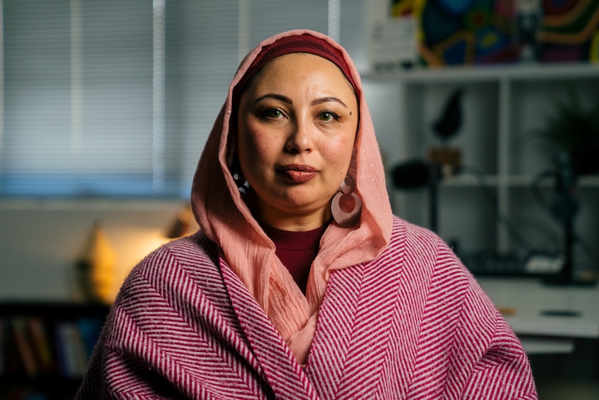 Roots TV Chair Aisha Novakovich smiling slightly at the camera wearing a hijab