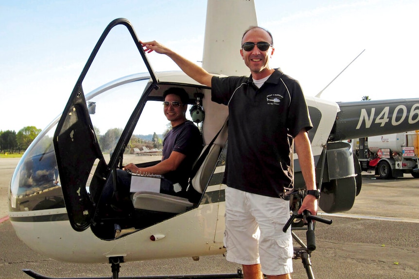 Photo shows pilot Ara Zobayan standing outside a helicopter.