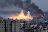 A skyline view of Gaza showing two white phosphorus bombs exploding in the distance.