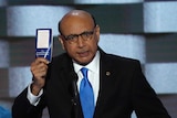 Khizr Khan holds up the constitution and looks at the camera