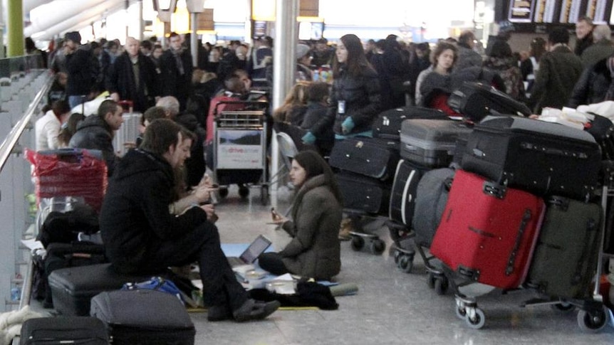 Airline passengers lie on the floor in Terminal 5 at Heathrow Airport