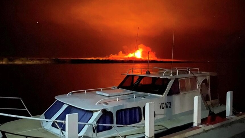 boat and fire in background 