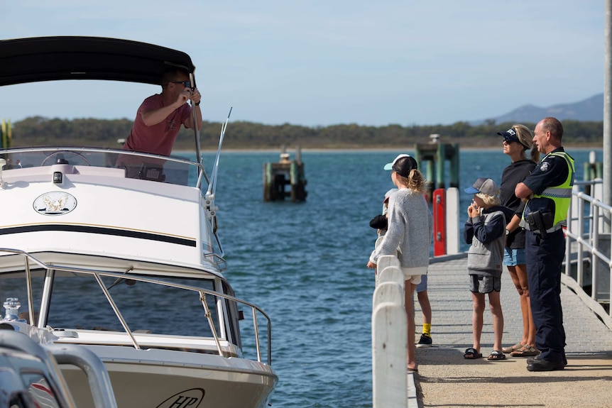 Policeman Paul Delaney chats with a family at the boat ramp in Port Welshpool.