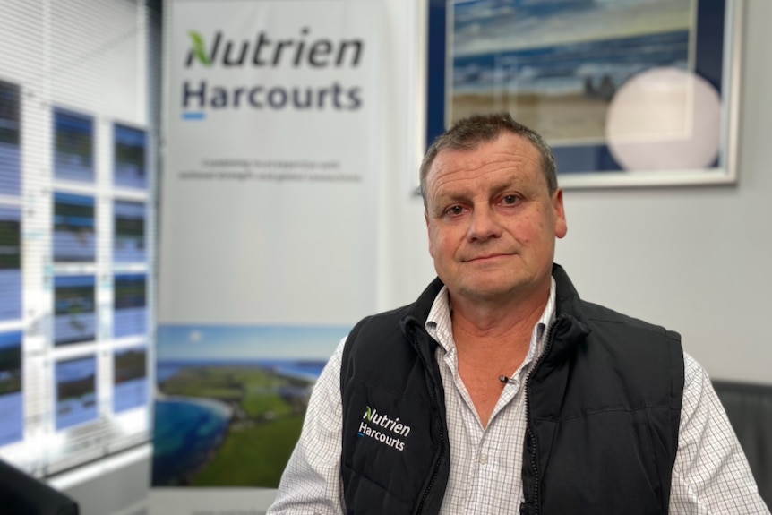 Nutrien Harcourts Tasmania director Michael Warren sits in his real estate office.